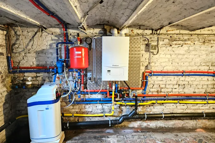 Chaufferie complète installée en cave : chaudière, vase d'expansion, adoucisseur et distribution